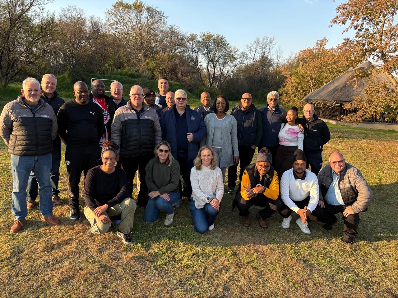 A group of people together outdoors, ready to grow